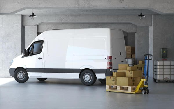 weißer Transporter mit Ladung im Hintergrund