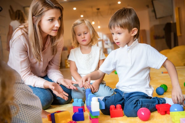 Aufgaben einer Erzieherin Frau spielt mit Kindern