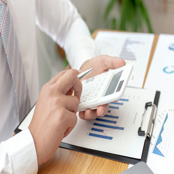finanzierung-investition Investor , der einen Taschenrechner verwendet, um die Kosten der Investition zu berechnen