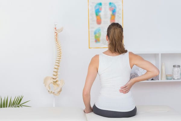 gesundheit-tipps-gesunden-ruecken Patientin, die sich an den Rücken fasst aufgrund von Rückenschmerzen
