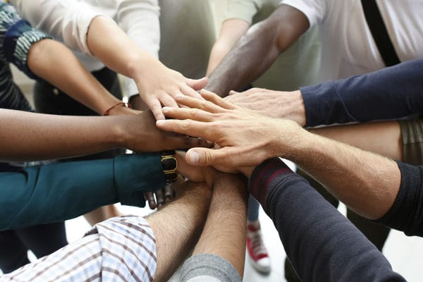 unternehmen-inklusives-unternehmen Geschäftsleute halten die Hände in der Mitte zusammen.