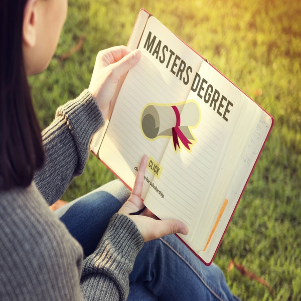 weiterbildung-mba Frau hält ein Buch in der Hand und macht Ihren Master Abschluss